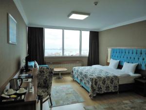 Cette chambre comprend un lit et une grande fenêtre. dans l'établissement Golden Lounge Hotel, à Istanbul