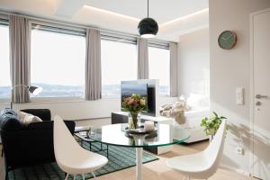 sala de estar con mesa de cristal y sillas blancas en PhilsPlace Full-Service Apartments Vienna, en Viena