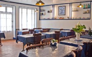 une salle à manger avec des tables, des chaises et un chiffon bleu dans l'établissement Hotel Magne, à Saurier