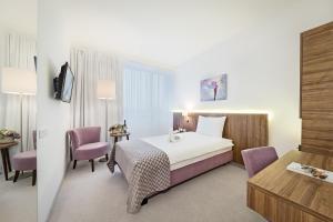 a hotel room with a bed and two chairs at Hotel Garden Hill in Velika Gorica +29 photos