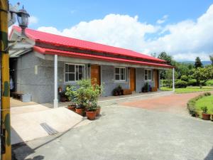 a house with a red roof and a driveway at Chin Shan B&B in Guanshan