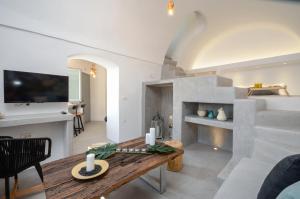 a living room with a table and a fireplace at Nissos House Santorini in Akrotiri