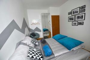 a bedroom with a bed with blue and black pillows at Krona Apartments in Bovec