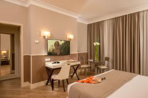 a hotel room with a bed and a table and chairs at Ludovisi Palace Hotel in Rome