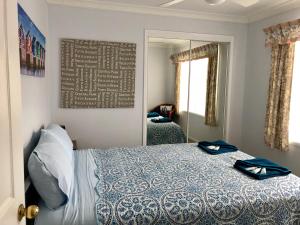 1 dormitorio con cama y espejo en Bayz on the River en Maroochydore