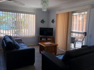 a living room with two couches and a television at Bayz on the River in Maroochydore