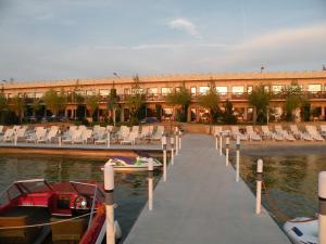 un muelle con sillas y un edificio sobre el agua en Hotel La Scoica Land en Mamaia-Sat