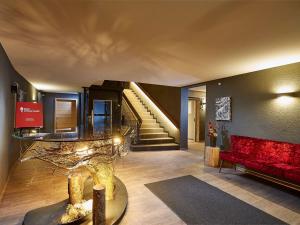 een woonkamer met een rode bank en een trap bij Black Forest Lodge in Feldberg