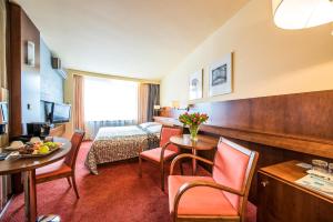 a hotel room with a bed and a table and chairs at Hotel Jana in Přerov