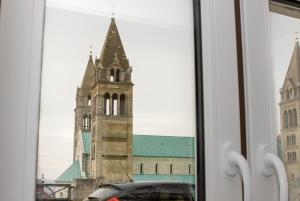 a reflection of a church tower in a window at Aradi Apartman in Pécs