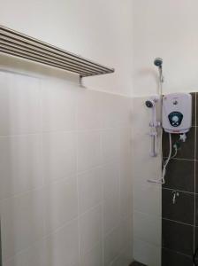 uma casa de banho com um chuveiro e um secador de cabelo na parede em D' Surya Lavender Inn em Pantai Cenang