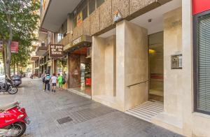 um grupo de pessoas andando por uma rua em frente a uma loja em YOUR HOME - Central Apartment em Barcelona