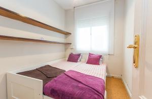 Un dormitorio con una cama con sábanas moradas y una ventana en YOUR HOME - Central Apartment, en Barcelona