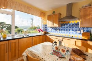 cocina con mesa, fregadero y ventana en Dunmanus Cottage West Cork, en Durrus