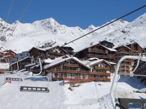 a ski lodge on a snowy mountain with a ski lift at Résidence l'Oxalys in Val Thorens