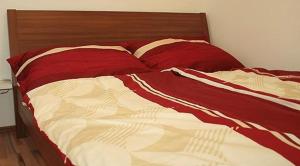 ein Bett mit roten und weißen Decken und Kissen in der Unterkunft Traditional Apartments Vienna in Wien