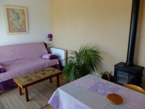 a living room with a couch and a stove at Un petit nid dans la garrigue in Saint-Pierre-des-Champs