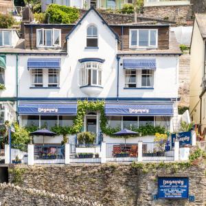 a white house on the side of a building at Deganwy Hotel in Looe