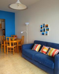 a living room with a blue couch and a table at Casa Lea in Ventimiglia