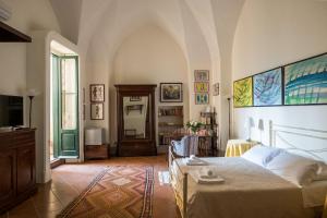 Palazzo Bernardini Suites في ليتشي: غرفة نوم بسرير وتلفزيون في غرفة