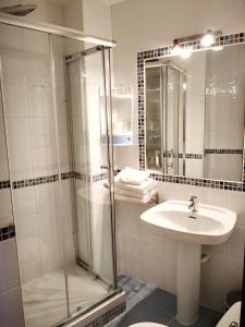 a bathroom with a shower and a sink at Hostal Alcántara in Avila