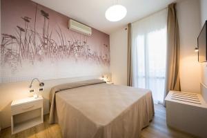 a bedroom with a large bed and a window at Hotel Villa Maria in Caorle