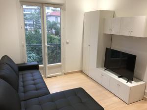 Una sala de estar con un sofá y un televisor de pantalla plana. en Nice Apartment in Menton French Riviera, en Menton
