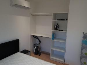 ein Schlafzimmer mit einem Bett und einem Schrank mit Regalen in der Unterkunft Nice Apartment in Menton French Riviera in Menton
