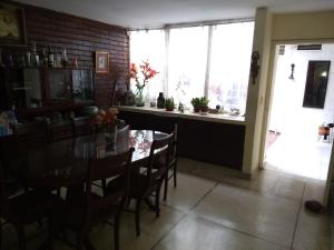 ein Esszimmer mit Tisch und Stühlen und einem Fenster in der Unterkunft Alcobas cerca al Éxito San Fernando in Cali