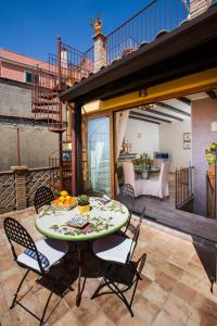 een patio met een tafel en stoelen op een balkon bij Taormina al Bacio apartment in Taormina