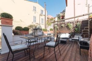 ローマにあるNavona Luxury and Charming Apartment with Terraceのパティオ(椅子、デッキ上のテーブル付)
