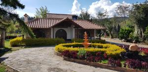 a garden with a fountain in front of a house at Finca Villa Patricia in Paipa