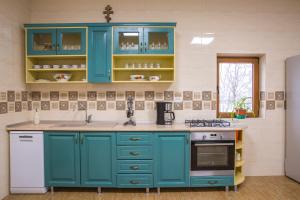 a kitchen with blue cabinets and a sink at Pensiunea Palaghia in Jurilovca