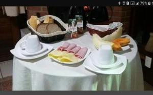 een tafel met een witte tafeldoek met voedsel erop bij Recanto dos Kerr in Monte Verde