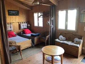 a room with two beds and a couch and a table at Chambres d'Hôtes L'Ardiegeoise in Ardiège