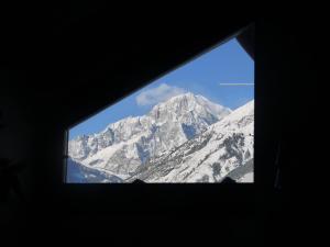 ラ・サルにあるTrilocale con vista Monte Biancoの窓越しに山の景色を望む