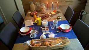 una mesa con un mantel azul con pan y velas en BnB Hasatrog Jenaz en Jenaz