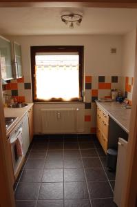 eine Küche mit einem Fenster und Fliesenboden in der Unterkunft DaMIsa House in Metzingen