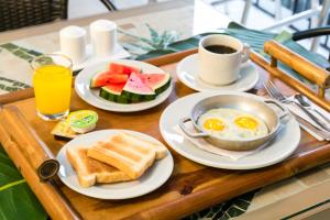 uma bandeja de pequeno-almoço com ovos e torradas e uma chávena de café em Hotel Casa Vallecaucana em Cali