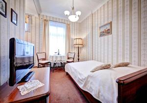 a bedroom with a bed and a table with a tv at Apartamenty Retro in Poznań