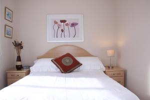 a bedroom with a white bed and two night stands at Achill in Bushmills