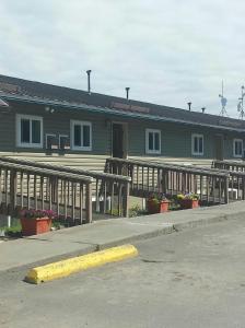 une maison avec une terrasse couverte et une clôture devant elle dans l'établissement Beluga Lake Lodge, à Homer