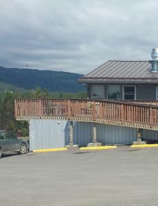 une maison avec une terrasse et une voiture garée sur un parking dans l'établissement Beluga Lake Lodge, à Homer