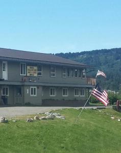 a building with an american flag in the grass at Beluga Lake Lodge in Homer