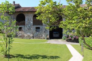 a stone house with a yard and a driveway at Casa Verità in San Daniele del Friuli