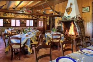 a restaurant with tables and chairs and a fireplace at Agriturismo Al Poggetto in Piana degli Albanesi