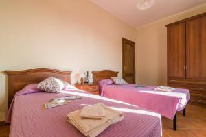 カーラゴノネにあるCasa Giovanniのピンクのシーツが備わる客室内のベッド2台