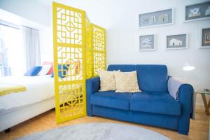 a room with a blue chair and a bed at Almada Story Apartments by Porto City Hosts in Porto