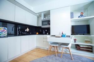 a white kitchen with a table and two chairs at Almada Story Apartments by Porto City Hosts in Porto
