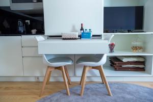 a white desk with two chairs in a kitchen at Almada Story Apartments by Porto City Hosts in Porto